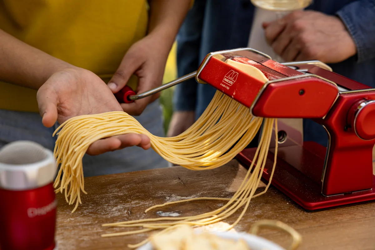 Manos cortando tagliatelle con una Marcato Atlas+ roja
